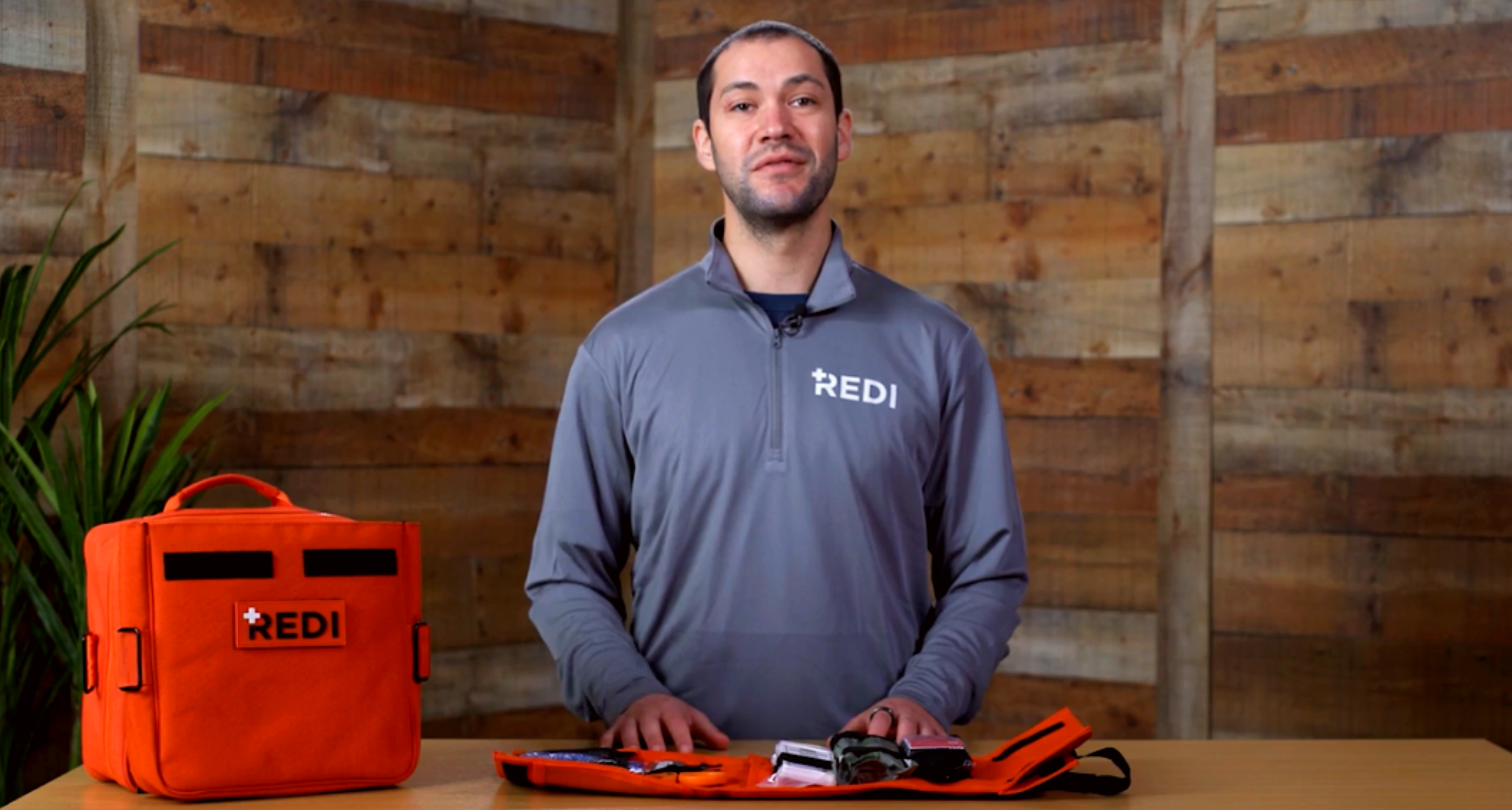 Redi Instructor, Gavin Dawson, standing with the Roadie Pro, quick release trauma pack open in front of him. 